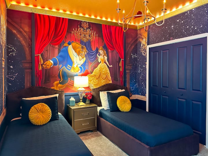 Zakoračite u bajku u ovoj sobi iz crtića Ljepotica i zvijer! Tamnocrvene zavjese i zidovi u tamnoplavoj boji okružuju mural u velikoj plesnoj dvorani, a na plišanim naslonjačima u tamnoplavoj boji vide se zlatni ukrasni jastuci. Kristalni luster i LED ukrasi pridonose čarobnom ambijentu