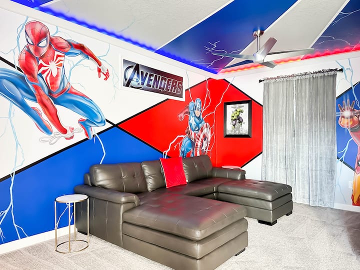 Otkrijte svog unutarnjeg heroja u ovom salonu u potkrovlju s temom Avengersa! Na zidovima su murali s likovima Kapetana Amerike, Iron Mana i Spider-Mana, a tu su i raskošni kauči od crne kože, otomani s prostorom za pohranu, stropni ventilator i strop koji izgleda kao da je u oluji, a na njemu su LED svjetla.    