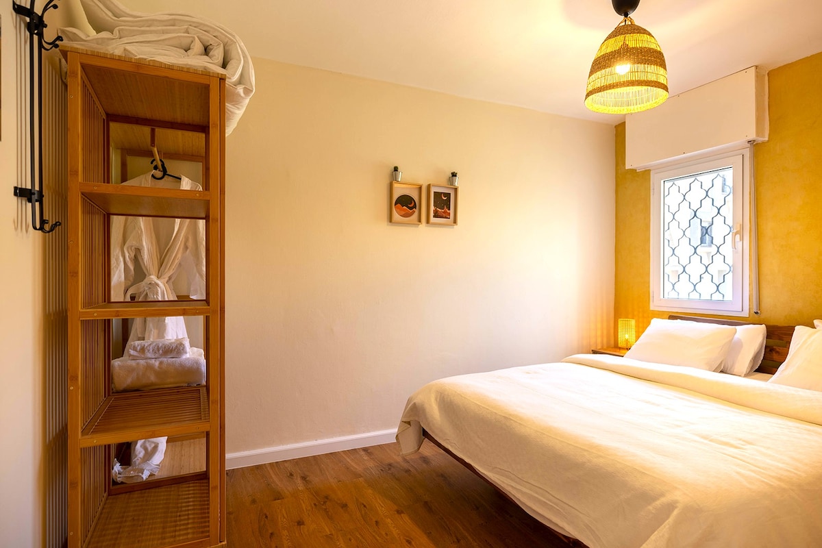 Bright bedroom with double bed, 2 dressers, 2 night light bulbs, closet, 2 body towels, 2 face pumps and 2 robes.