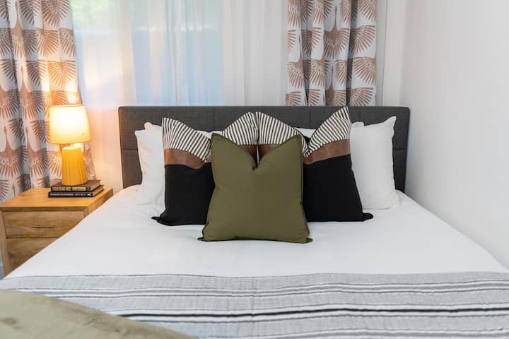 オックスボーキャビンのゲストベッドルームでは、洗練されたデザインの要素、最適な休息のための遮光シェード、居心地の良いクイーンサイズベッドがあり、安らかな夜の睡眠を確保しています。