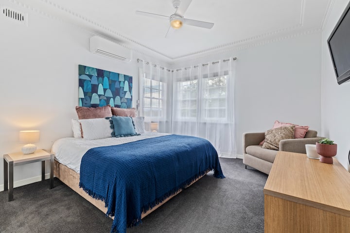 Dormitorio principal con cama tamaño king, TV y armario con espejo incorporado.