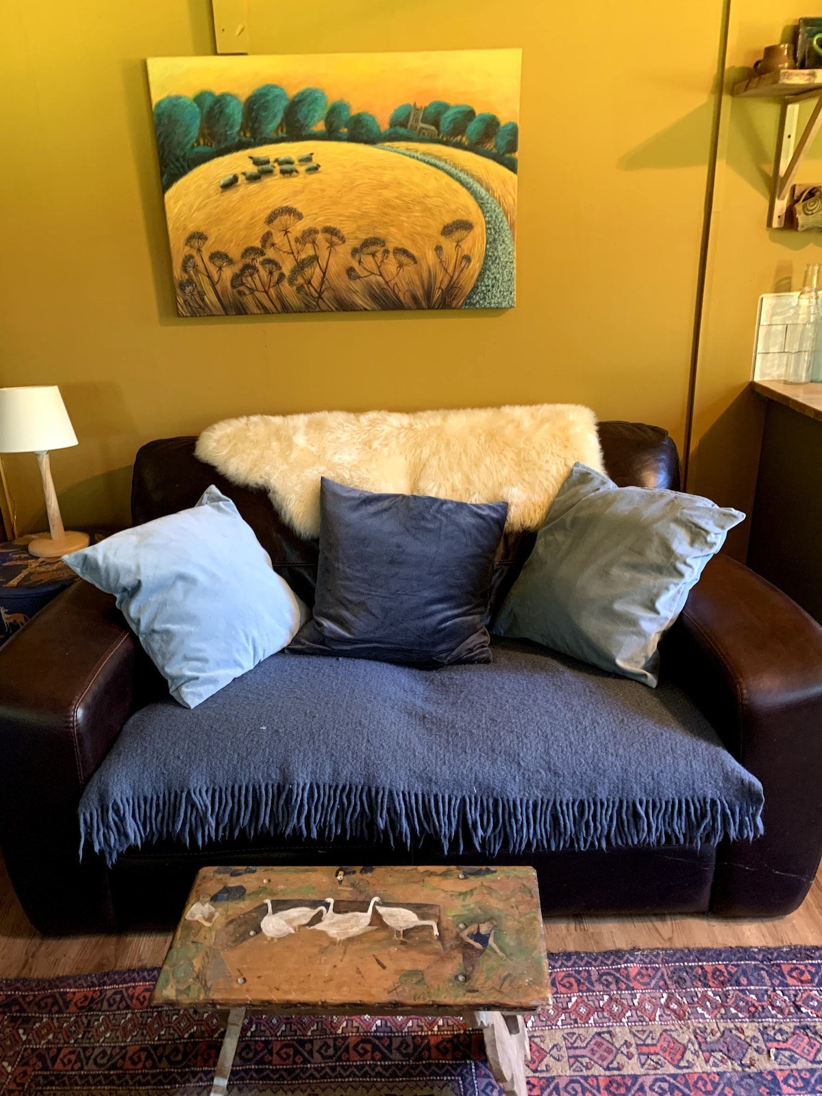 De gezellige bank met rustieke kruk geschilderd door een lokale kunstenaar. Geweldig om te lezen en te genieten van het rustige toevluchtsoord.