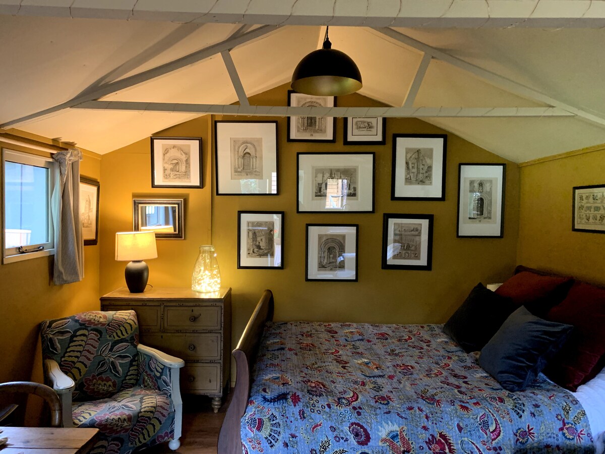 Het slaapkamergedeelte van deze ruime hut met Norfolk-scènes aan de achterkant en uitzicht over het veld.