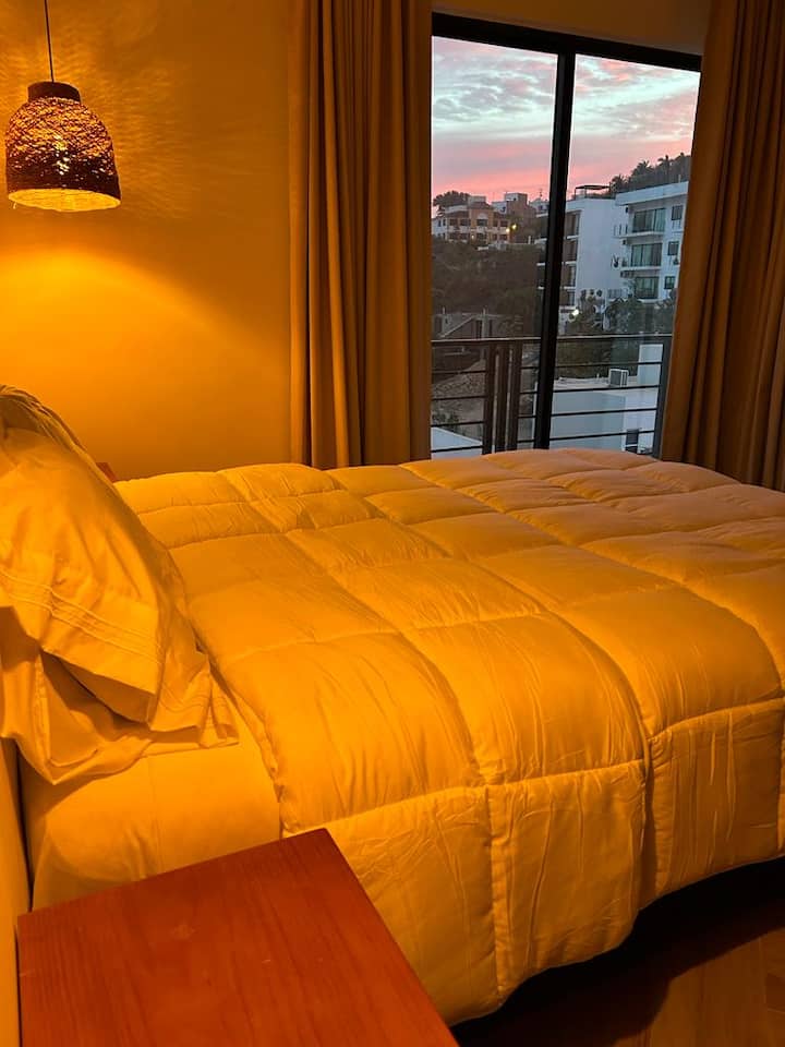 Habitación principal con una hermosa vista al atardecer y entrada privada al balcón