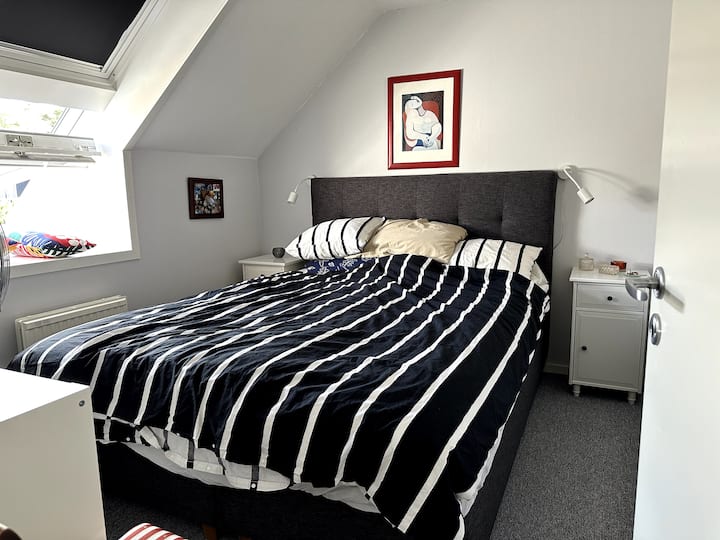 חדר שינה למעלה עם מיטת קווין סייז ושני ארונות לחפצים אישיים.