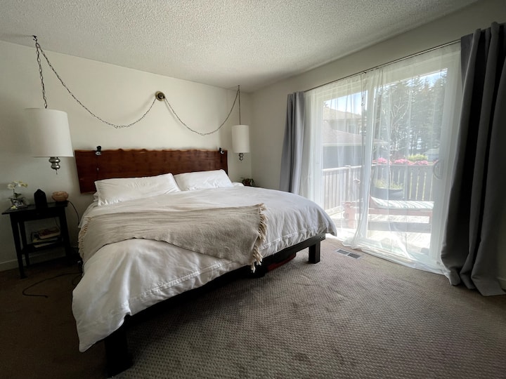 Chumba cha kulala cha msingi kilicho na kitanda cha kifalme na sitaha ya mwonekano wa bahari inayofaa kwa kahawa yako ya asubuhi. 