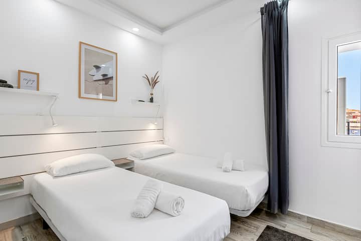 غرفة نوم ثانية مع مكيف وأسرّة مفردة وخزانة ملابس