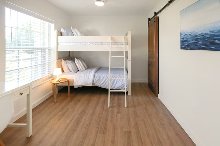 غرفة نوم بسريرين بطابقين ومكتب