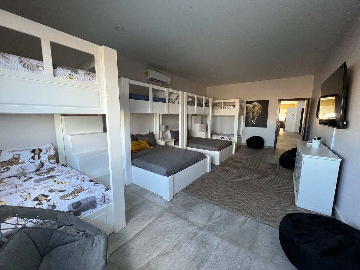 二段ベッドルームは10名様までご宿泊いただけ、充電ステーション、75インチスマートテレビ、ビーンバッグ、椅子が備わっています。 ビーチで長い1日を過ごした後にぴったりです。 
