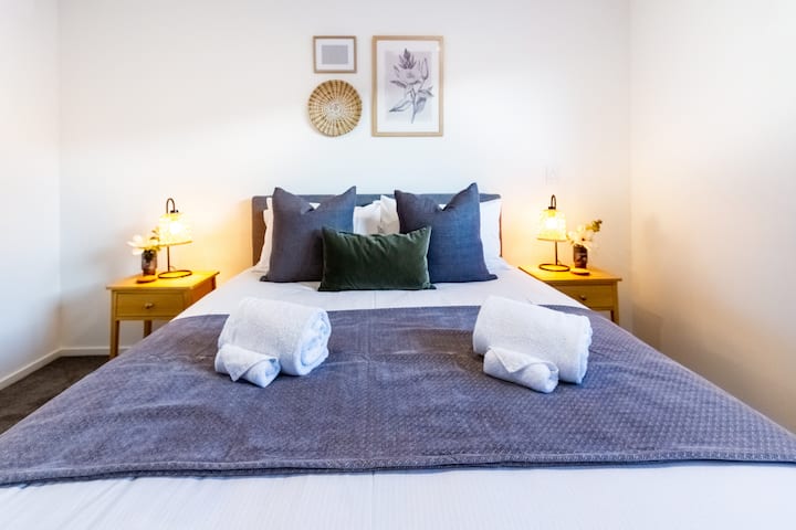 ห้องนอนใหญ่ที่หรูหราและได้รับการออกแบบมาอย่างดีพร้อมเตียงควีนไซส์