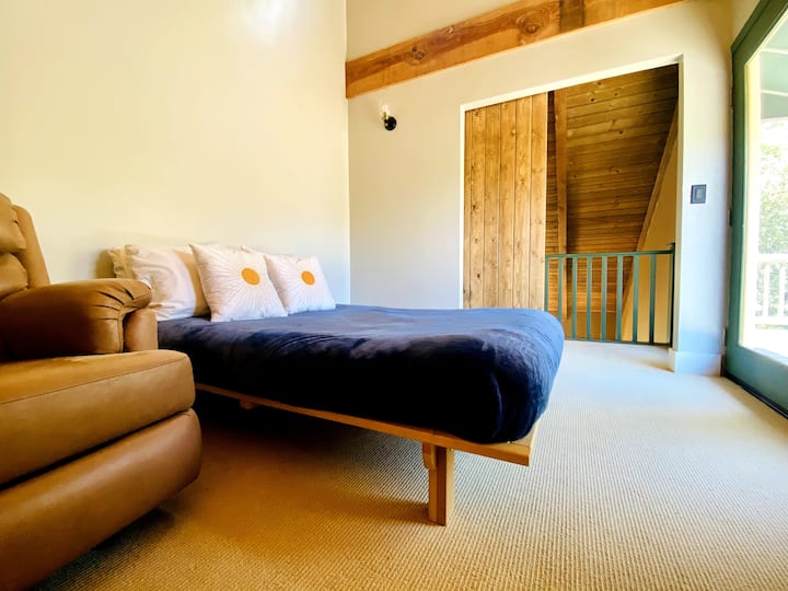 Трета спална соба со кревет во целосна големина, лежалка, телевизор Roku и мал балкон. 