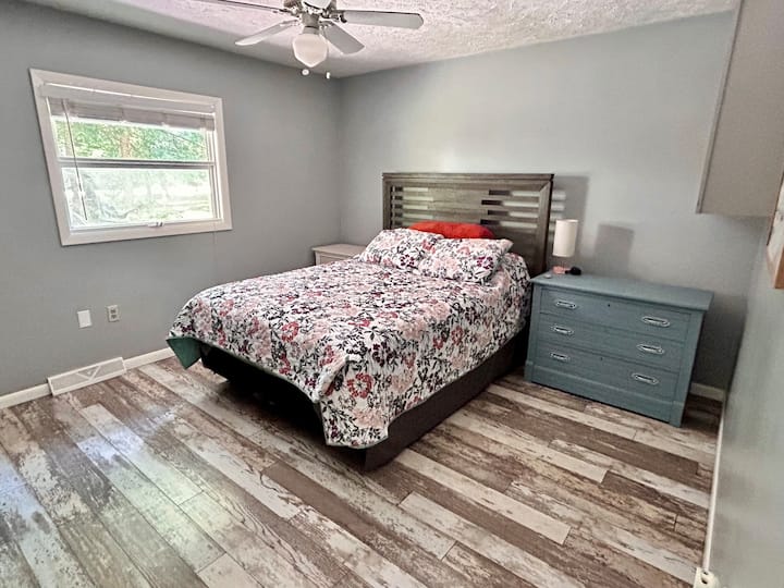 El segundo dormitorio tiene una cama tamaño queen, un escritorio incorporado, un televisor inteligente y una estantería abastecida.