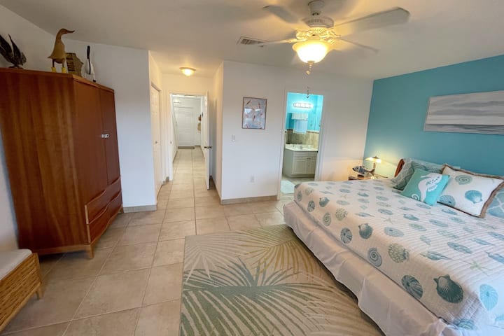 Chumba cha kulala cha msingi chenye mwonekano wa barabara ya ukumbi, mlango wa mbele na bafu la kujitegemea.