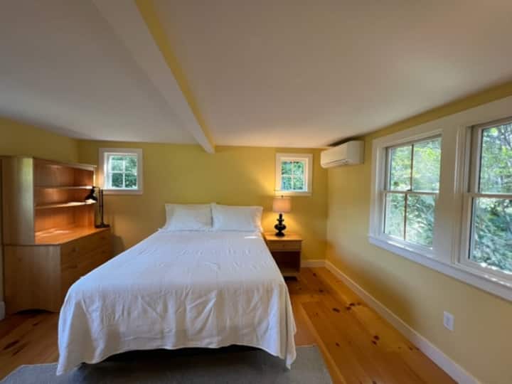 Dormitorio grande en planta baja con cama queen nueva y aire acondicionado mini-split.