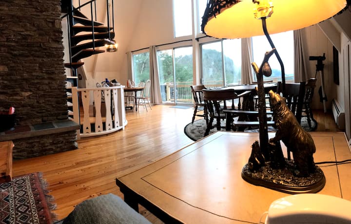 Kuzunguka sehemu ya kuishi iliyo wazi ya sakafu kuu (ikiwa na sofa ya povu na meza mahususi). Hii ni Barney upande wa mbele na meza ya mchezo, darubini, meza ya kulia chakula, ngazi mahususi, na mwonekano wa bonde la panoramic. Angalia kazi mahususi ya mbao.