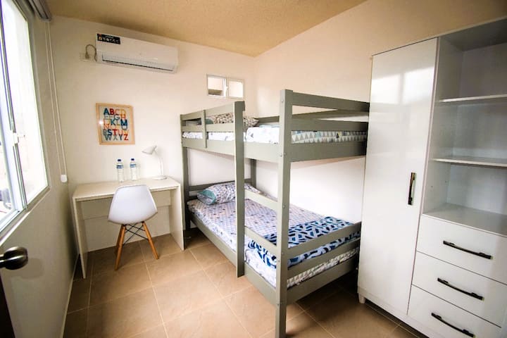 Chambre #2 avec lit superposé, penderie, bureau et la climatisation.