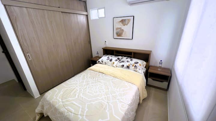 Chambre principale avec lit double, climatisation et grand placard.