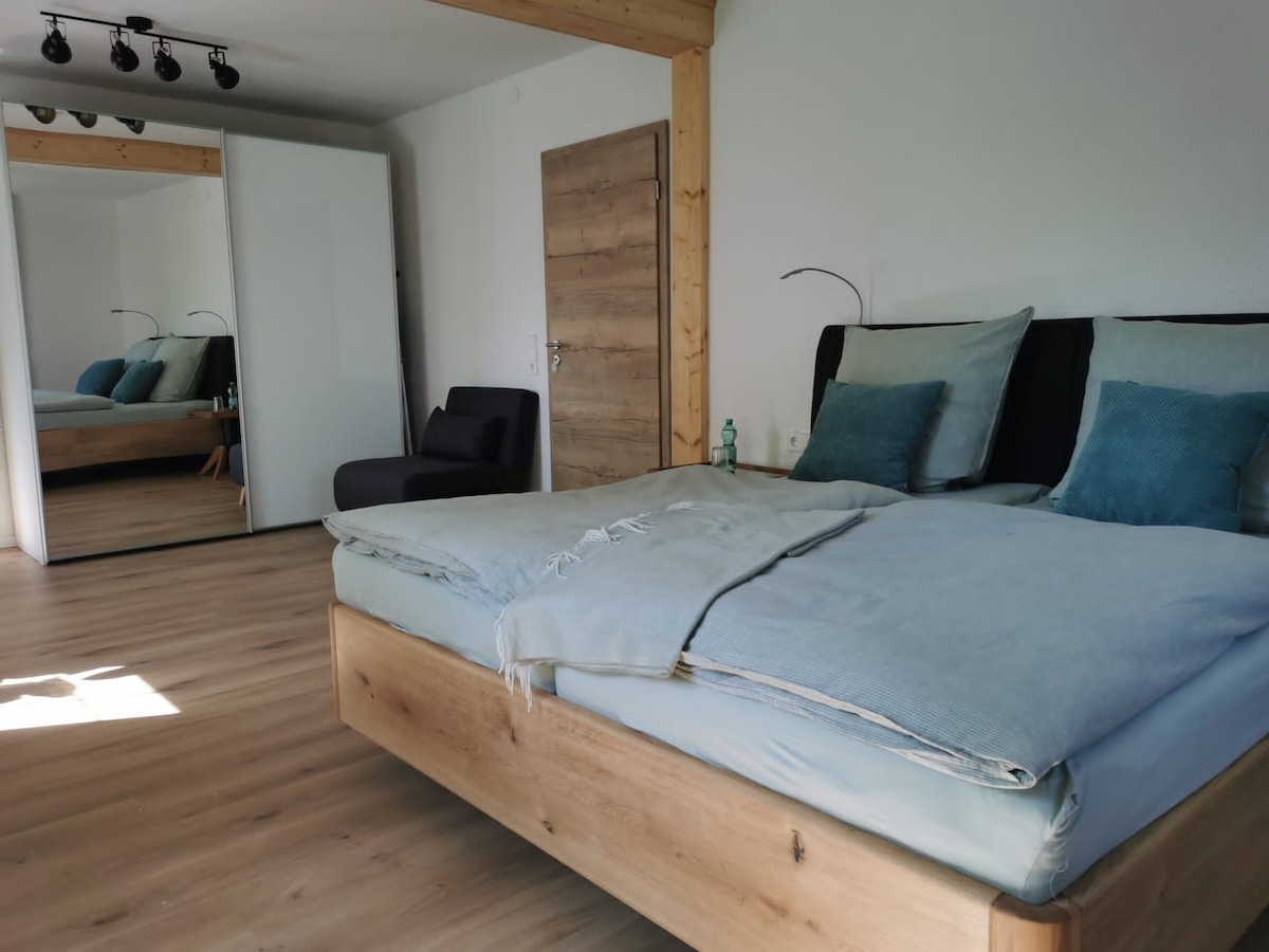 Cama doble de 1,80m × 2,00 m con dos almohadas, así como una silla para dormir de 0,77 m × 1,91m con una almohadilla superior.