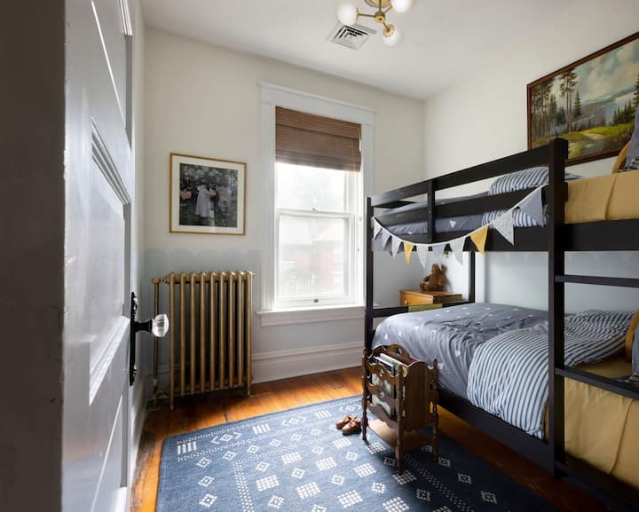 سريران بطابقين مع ديكور ممتع في غرفة الأطفال هذه