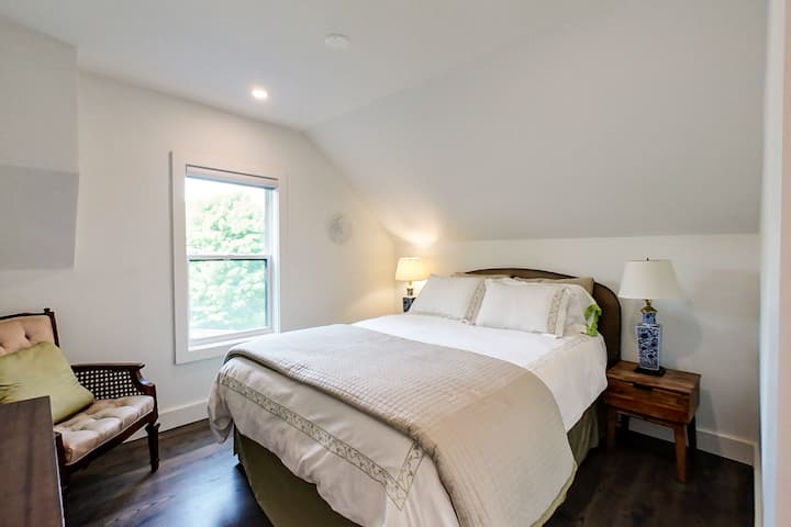 חדר שינה ראשי עם מיטת קווין סייז, כיסא ושידה