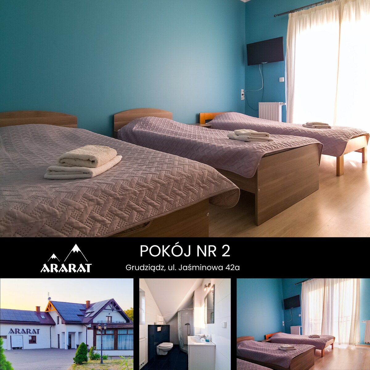 The room features three individual beds arranged neatly against a vibrant blue wall. A light, textured blanket covers each bed, and towels are placed at the foot. Natural light enters through a large window, complemented by light curtains.