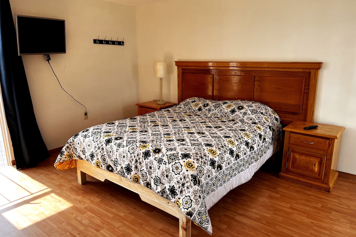 Chumba cha kulala kilicho na kitanda cha ukubwa wa kifalme, kitanda cha sofa na Televisheni mahiri.