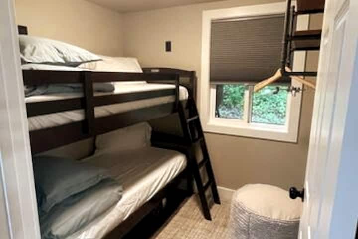 Вторична спалня с двуетажни легла. Всеки контакт има USB A и C портове за зареждане. По - високи контакти за горното легло. Закачалка и място за съхранение. Затъмняващи се нюанси във всяка стая. 