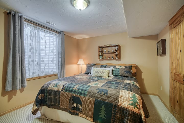 Светла спалня с голямо двойно легло и дървени акценти