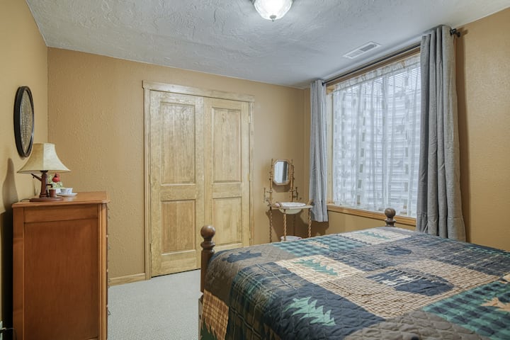 Спалня в сутерен с голямо двойно легло и естествена светлина