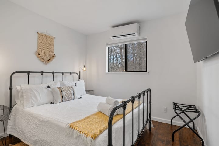 Upstairs Bedroom: Modern charm with a queen bed, forest views, and sleek amenities await you!