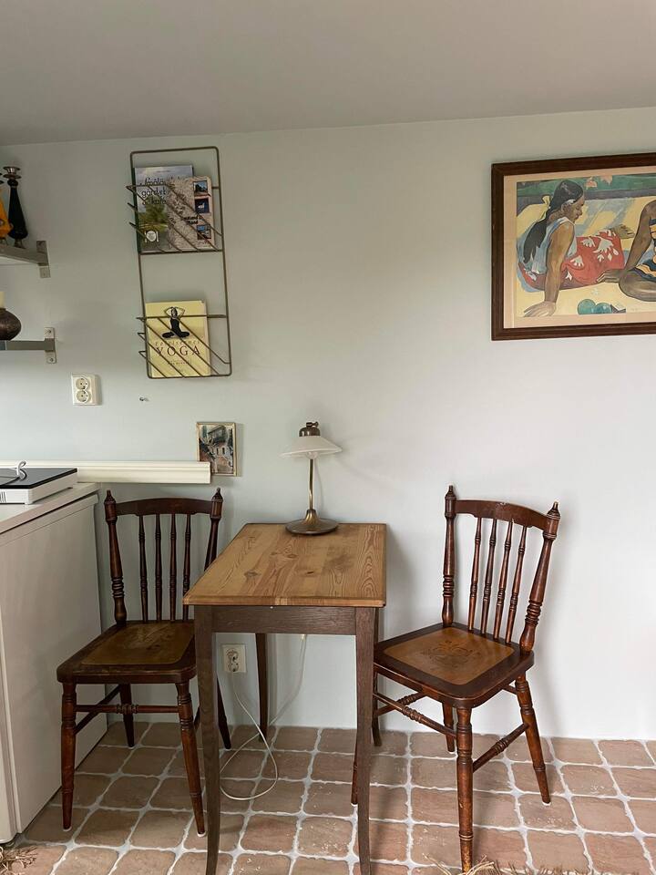 Ni nyumba yenye rangi nyekundu kwa hivyo jiko/sebule iko ndani yake. 
Picha ya meza ya kulia chakula