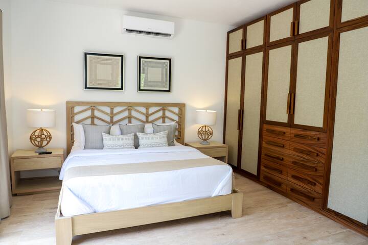 Მთავარი საძინებელი 2, რომლიდანაც დიდი ზომის საწოლი და ბაღის ხედი იშლება