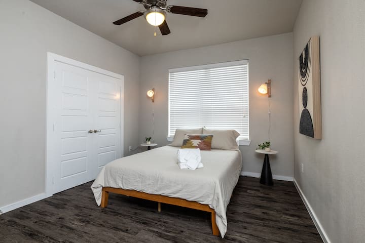 Inviting fourth bedroom with a queen bed and soft hanging lights on each side—simple, stylish, and made for a peaceful night's sleep. This bedroom is located upstairs.