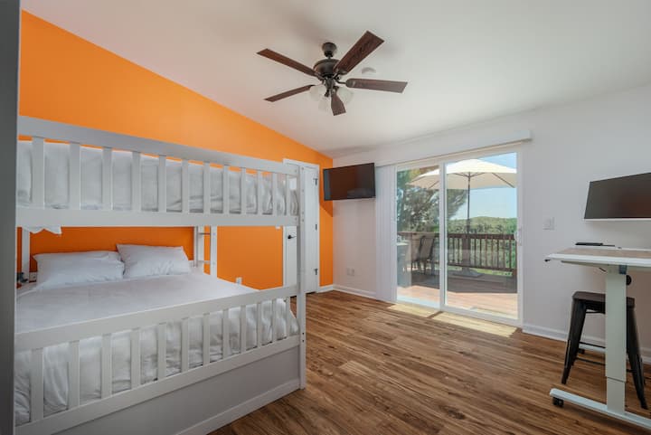 Orange Room uključuje 2 velika kreveta i 1 krevet za jednu osobu koji se izvlači odozdo, 43' Smart TV i uredski prostor s pričvršćenim monitorom + podesivi radni stol koji vam omogućuje da se usredotočite na sve radove i dvostruka vrata koja se zatvaraju kako biste imali privatnost. 