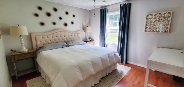 Bedroom 1 with tempur-pedic king mattress, desk, tv, and blackout drapes