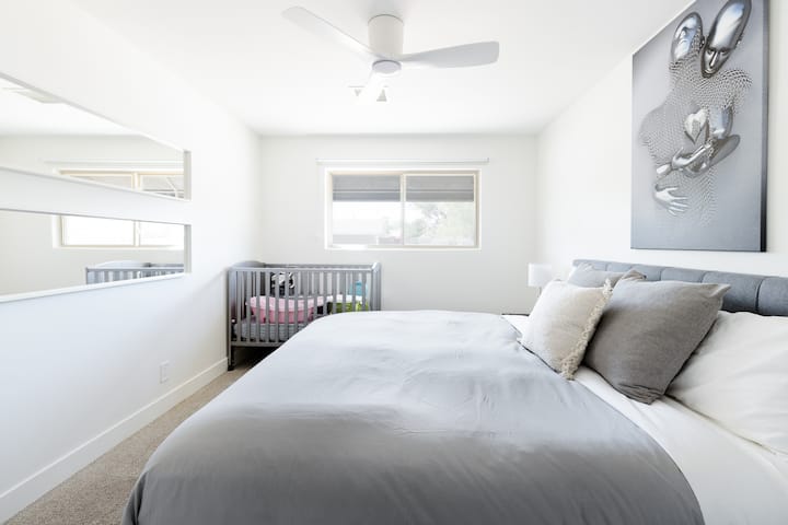 Bedroom #2. Features a king size bed with a luxe mattress, pillows, & linens + full size crib.