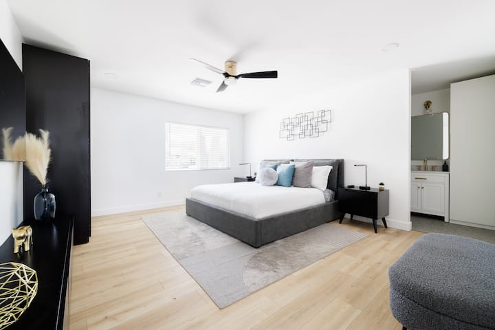 Spacious master suite features a king size bed with a luxe mattress, pillows, & linens.