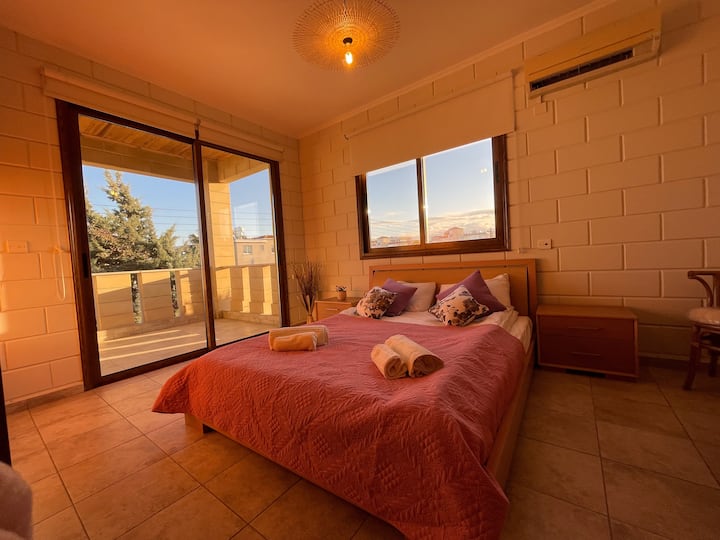 Двойна спалня на 2 - ри етаж със самостоятелна баня, кът за кафе, два гардероба и балкон с изглед към залеза.