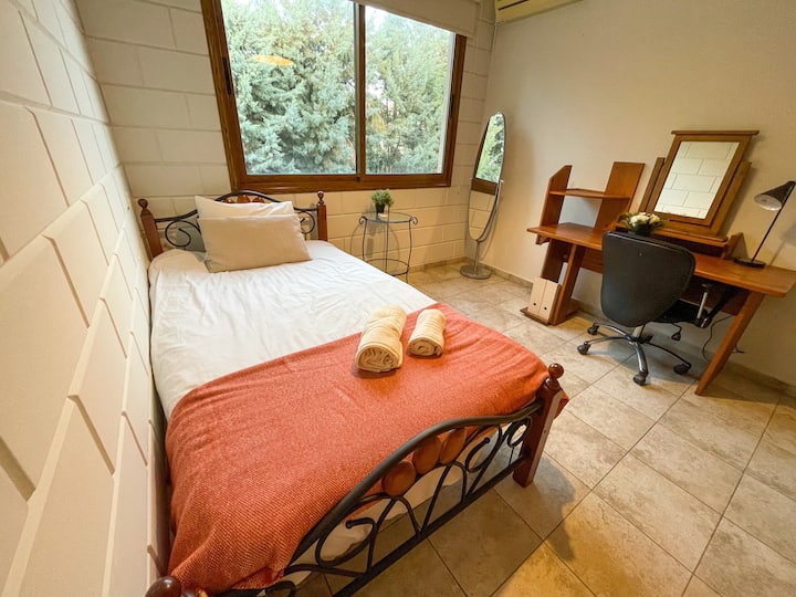 Уютна единична спалня с гардероб и работна зона.