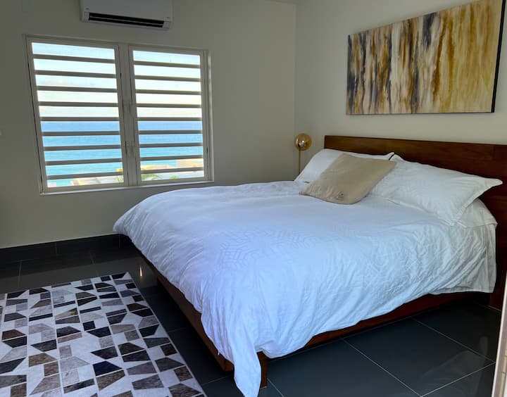 Dormitorio con cama tamaño king y vistas al mar