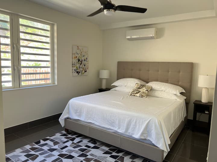 Dormitorio con cama tamaño king y vista al jardín