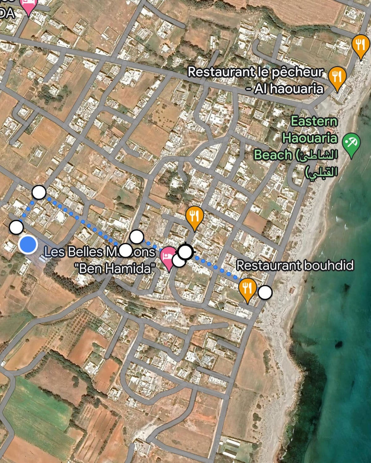 A detailed map highlights the location of local points of interest, including beaches and restaurants. Roads and pathways are clearly marked, showcasing the proximity of amenities to the accommodation. The coastal area is depicted, indicating its accessibility for visitors.