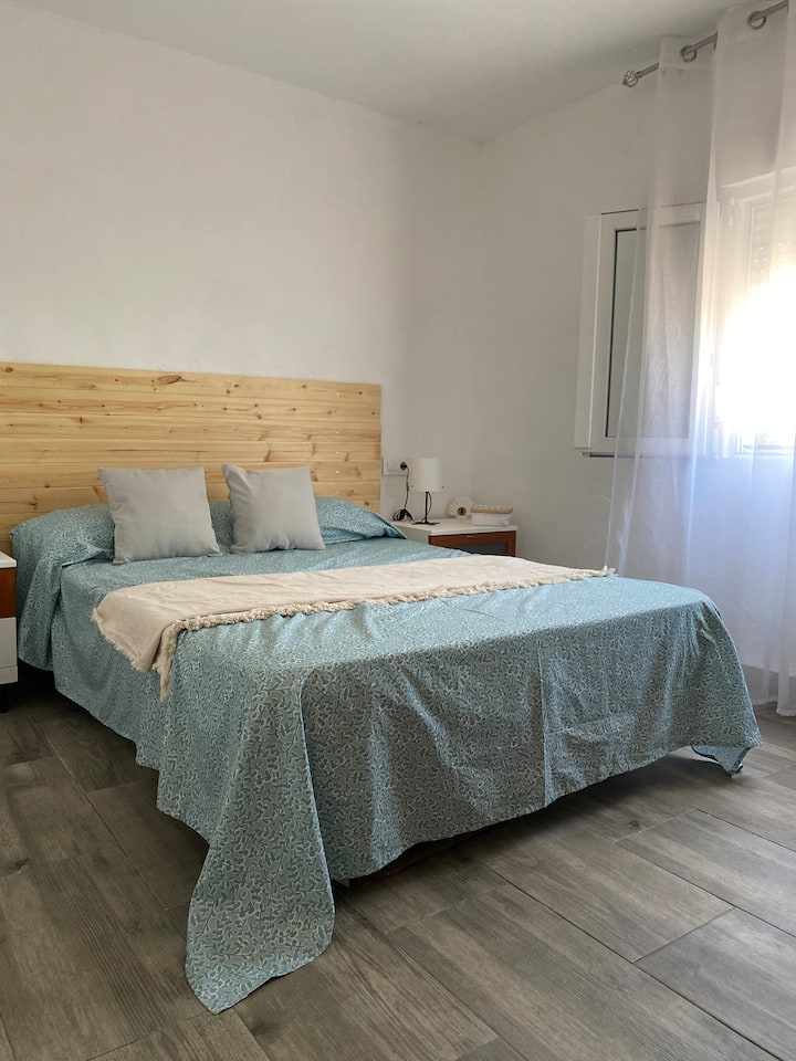 Aerogeneradores en una llanura de hierba, con un cielo azul.