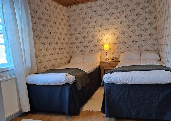 Soveværelse med 2 90 cm senge, natbord, stol med lille bord