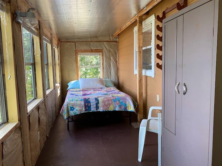 Cabane pour les voyageurs, lit double sur le porche fermé