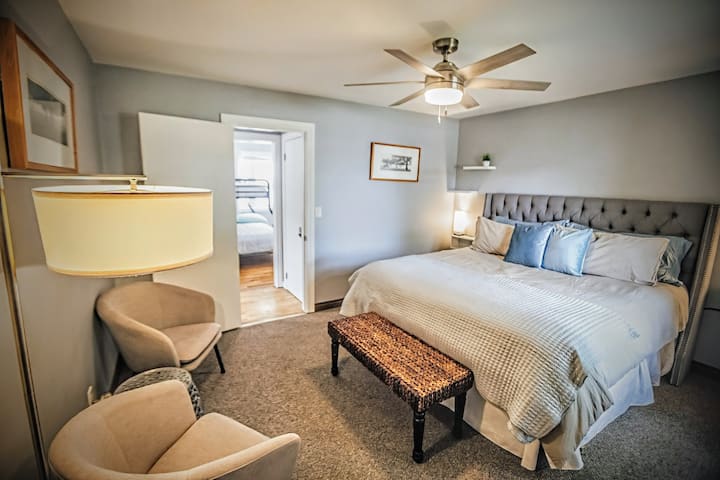 เตียงคิงไซส์บนชั้นหลักพร้อมพื้นที่นั่งเล่นและตู้เสื้อผ้าแบบเดินเข้าได้