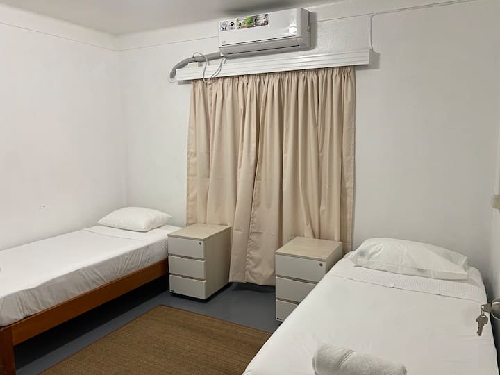 เตียงเดี่ยว 2 เตียง + โต๊ะข้างเตียง/ลิ้นชัก + เครื่องปรับอากาศ + พื้นที่แขวนตู้เสื้อผ้า + ผ้าปูที่นอนและผ้าขนหนู