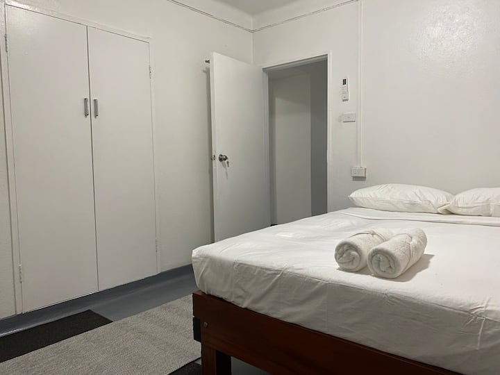 ห้องนอนขนาดควีนไซส์ + ที่วางของตอนกลางคืน + เครื่องปรับอากาศ + พื้นที่แขวนตู้เสื้อผ้า + เตารีดและกระดาน + ผ้าปูที่นอนและผ้าขนหนู