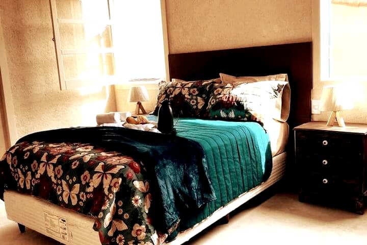 Suite 2, kwenye ghorofa ya pili ya nyumba. Safi sana, yenye meza za ubao wa kichwa, vivuli vya taa na kabati la uashi.