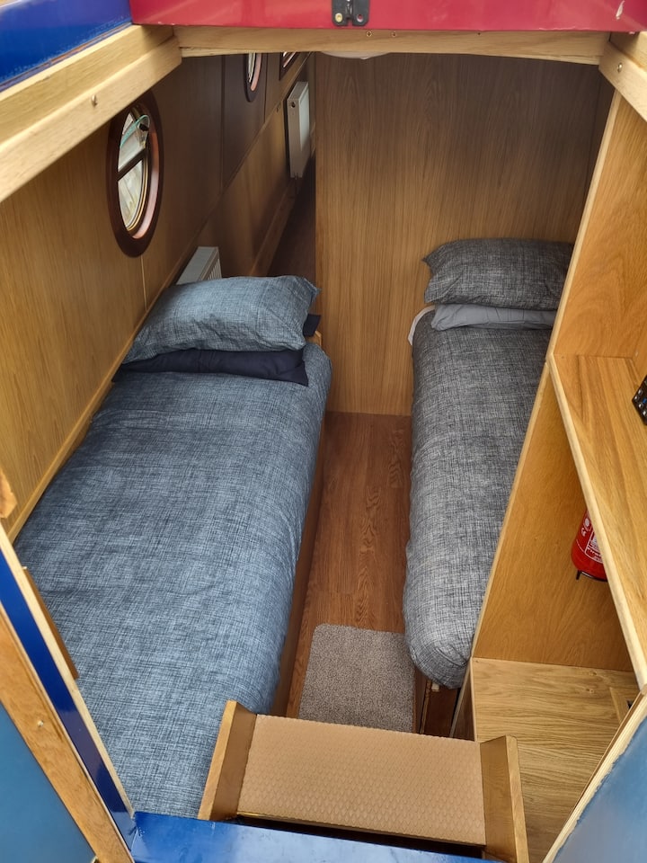 As you enter from the stern (back) you have the two fixed single beds. Don't be fooled as both are fitted with gas strut assisted ottoman hinges meaning you have massive storage space under the beds!
